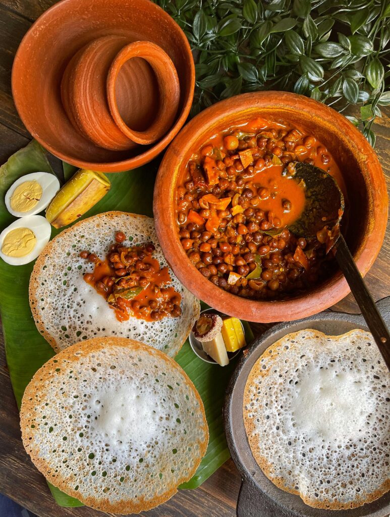 Culinary Journeys at SV Luxe Resort, Munnar – Where Taste Meets Luxury Delicious Kerala breakfast featuring appam, spicy curry, boiled eggs and banana slices served on banana leaf.